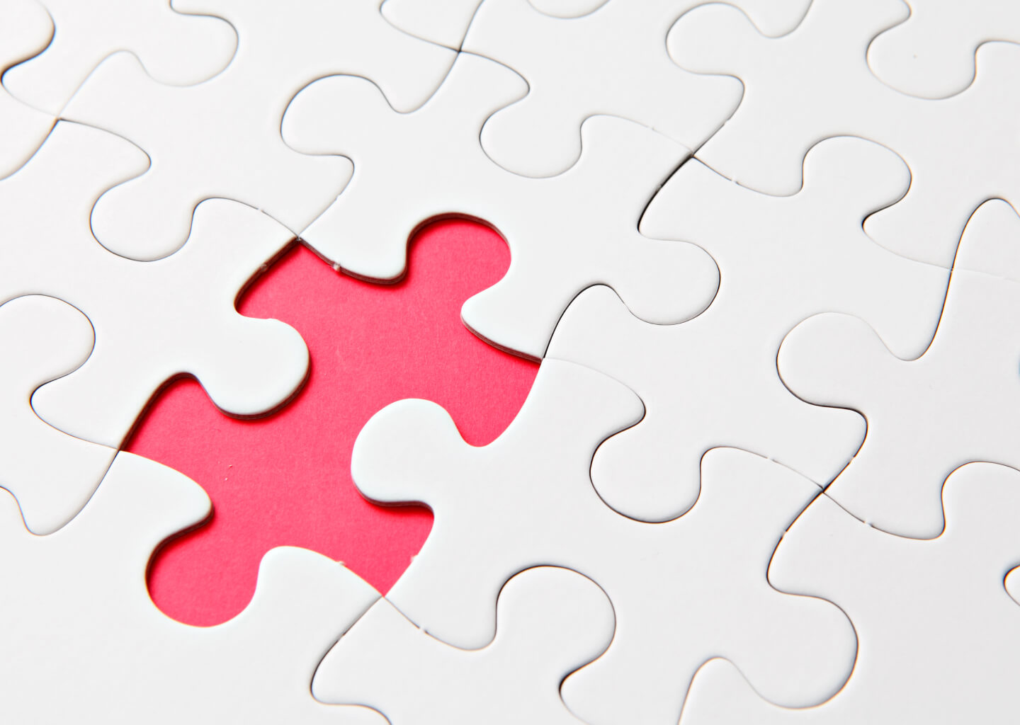 Puzzle pieces with one pink piece visible
