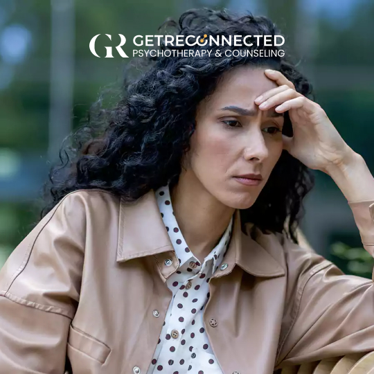 a woman with long curly hair holding her head