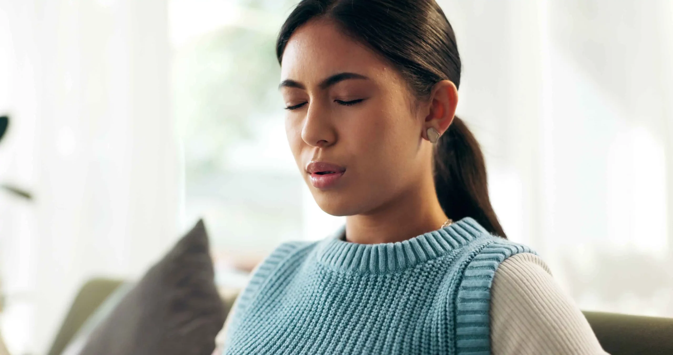 woman-pain-and-breathing-on-couch-for-anxiety