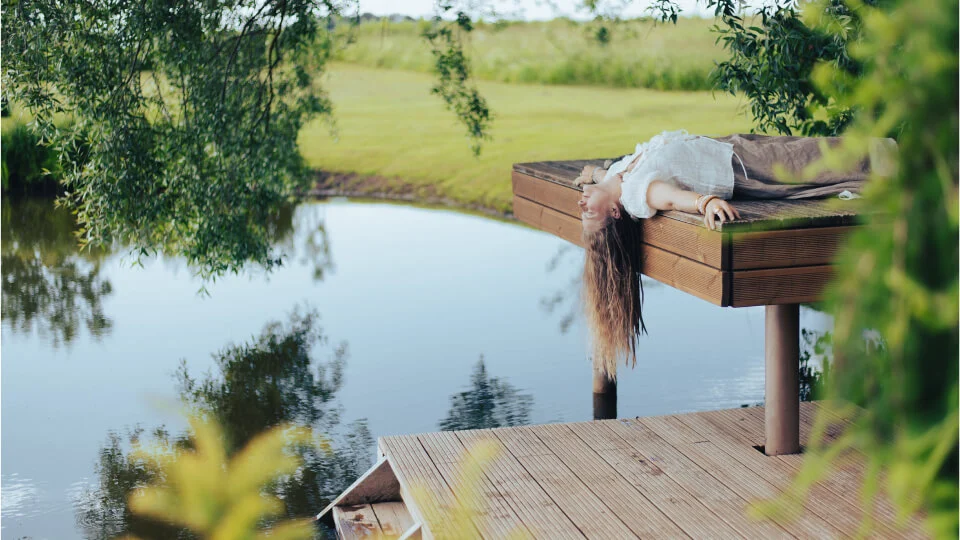 a woman lying on a dock over water