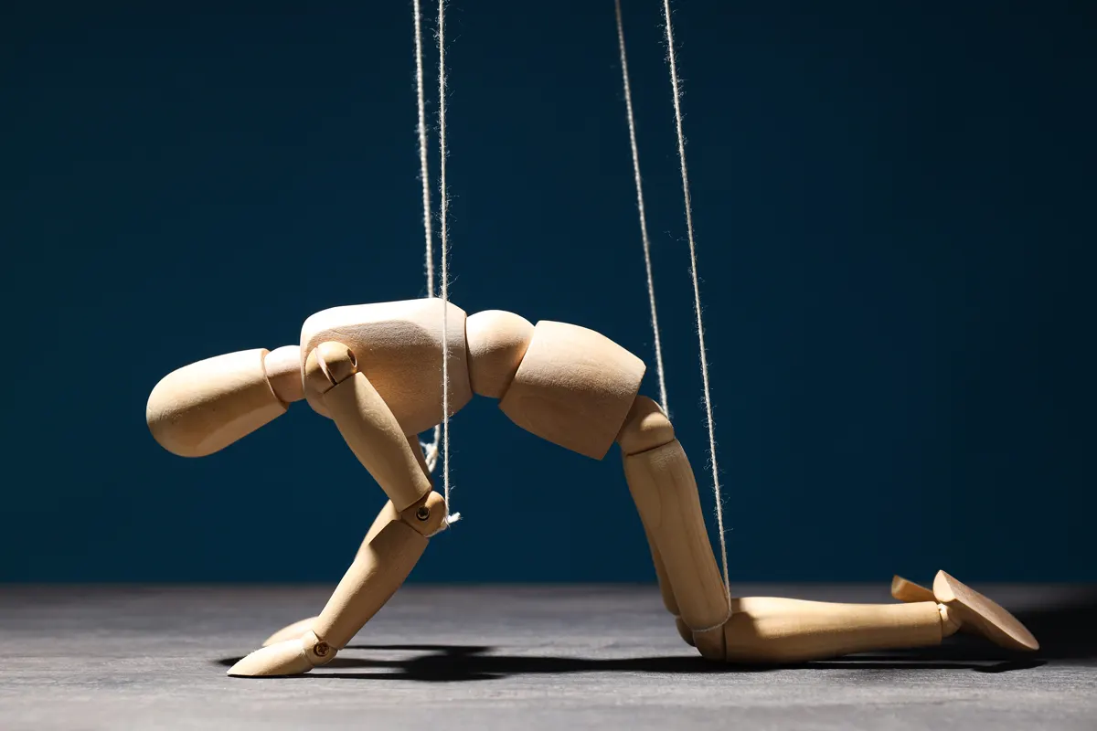 A wooden puppet suspended from a string, showcasing its intricate craftsmanship and playful design.