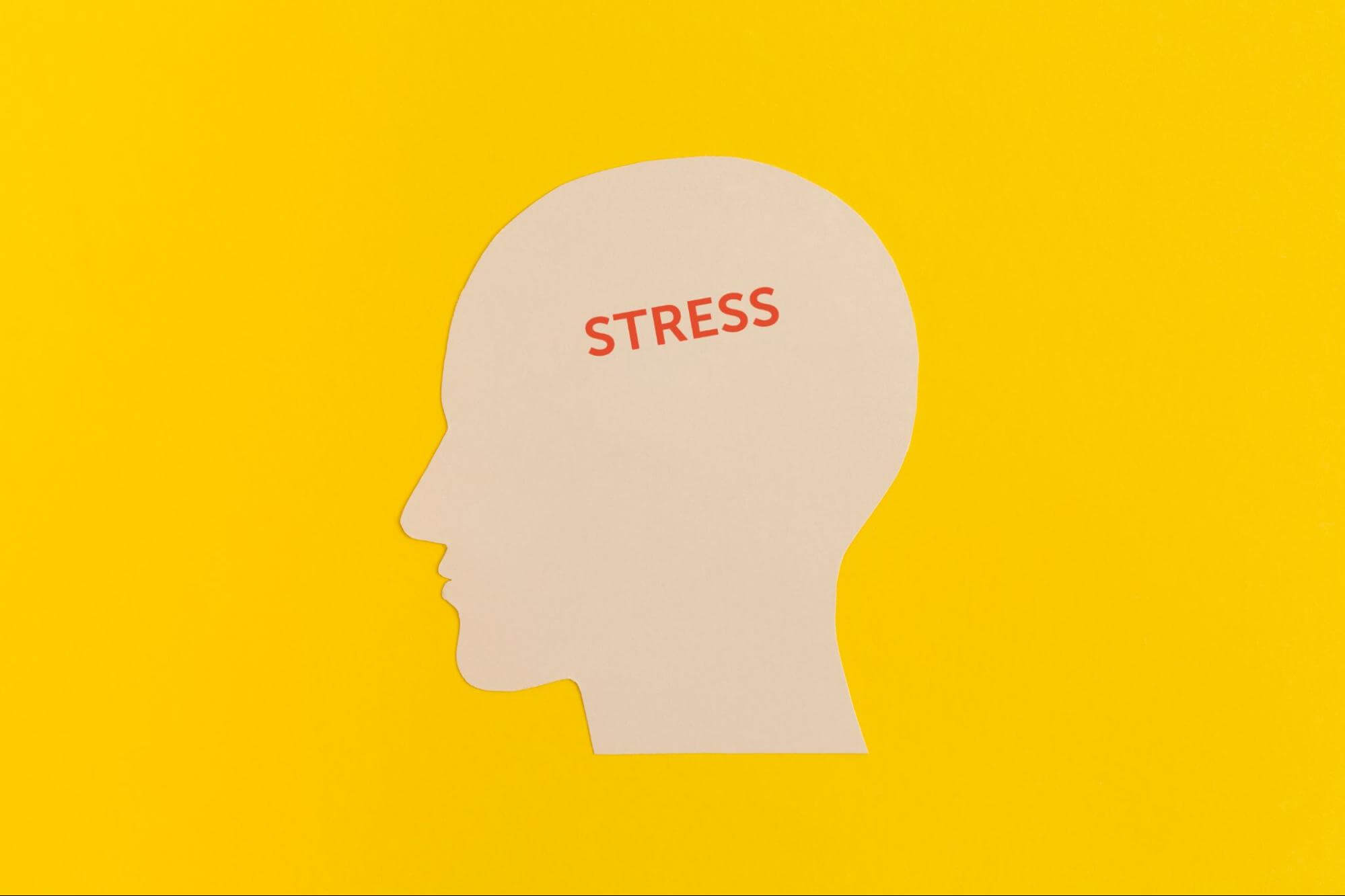 A shape of a man appears stressed against a yellow background, holding his head, with red details highlighting his feelings of anxiety.