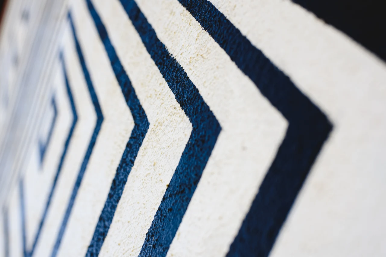 Close-up of a wall featuring alternating blue and white stripes, creating a bold and modern visual effect.