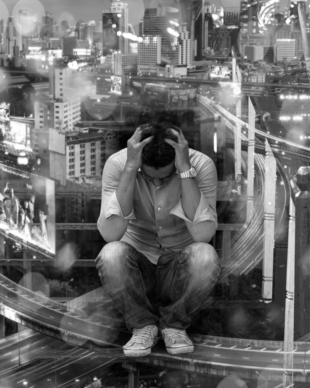 A distressed man sits overwhelmed against a hectic city backdrop. Image used by Get Reconnected Psychotherapy and Counselling Services. Contact info@getreconnected.ca.