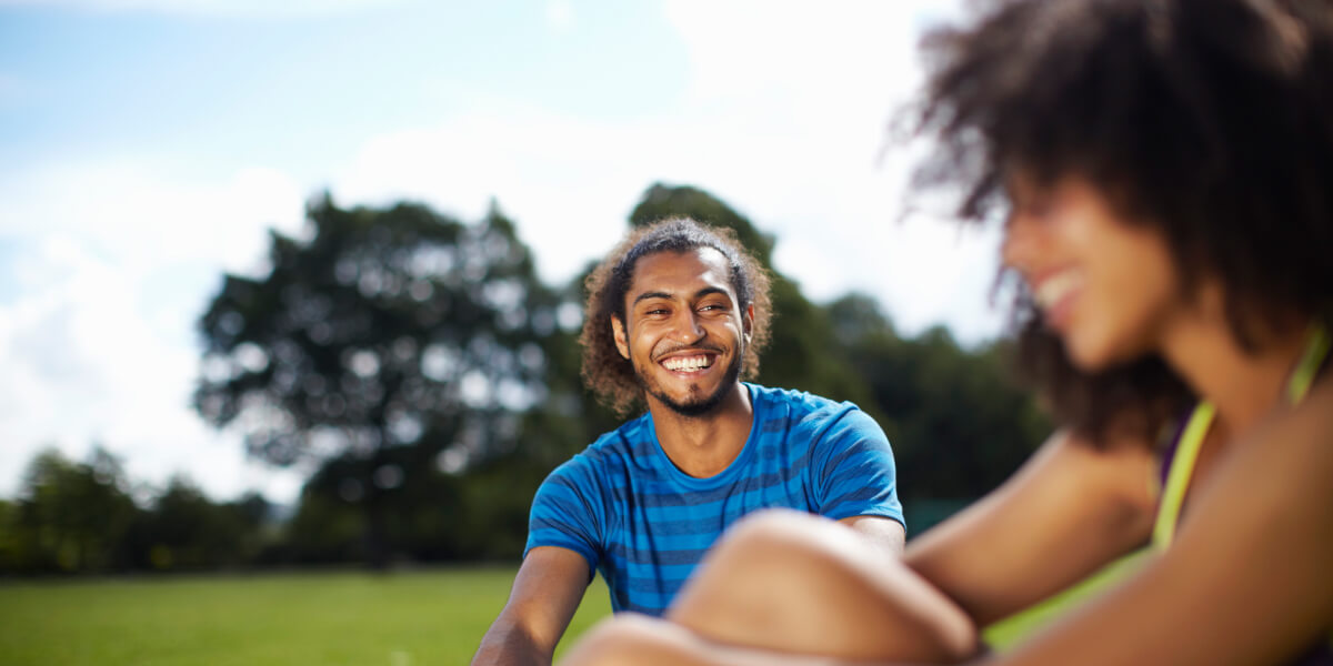 Young soccer couple taking a break in park