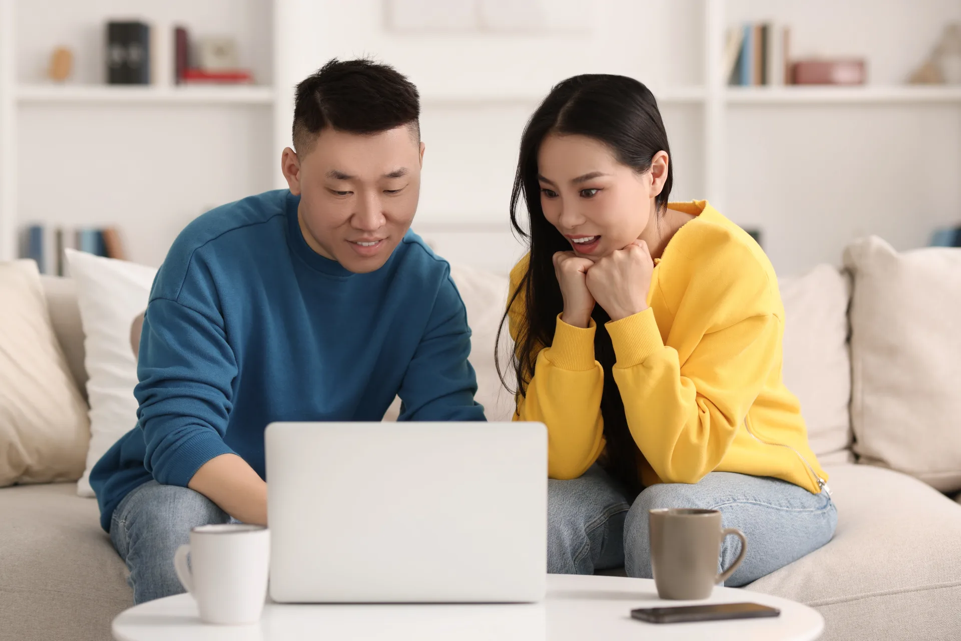 Couple looking at a laptop together at home