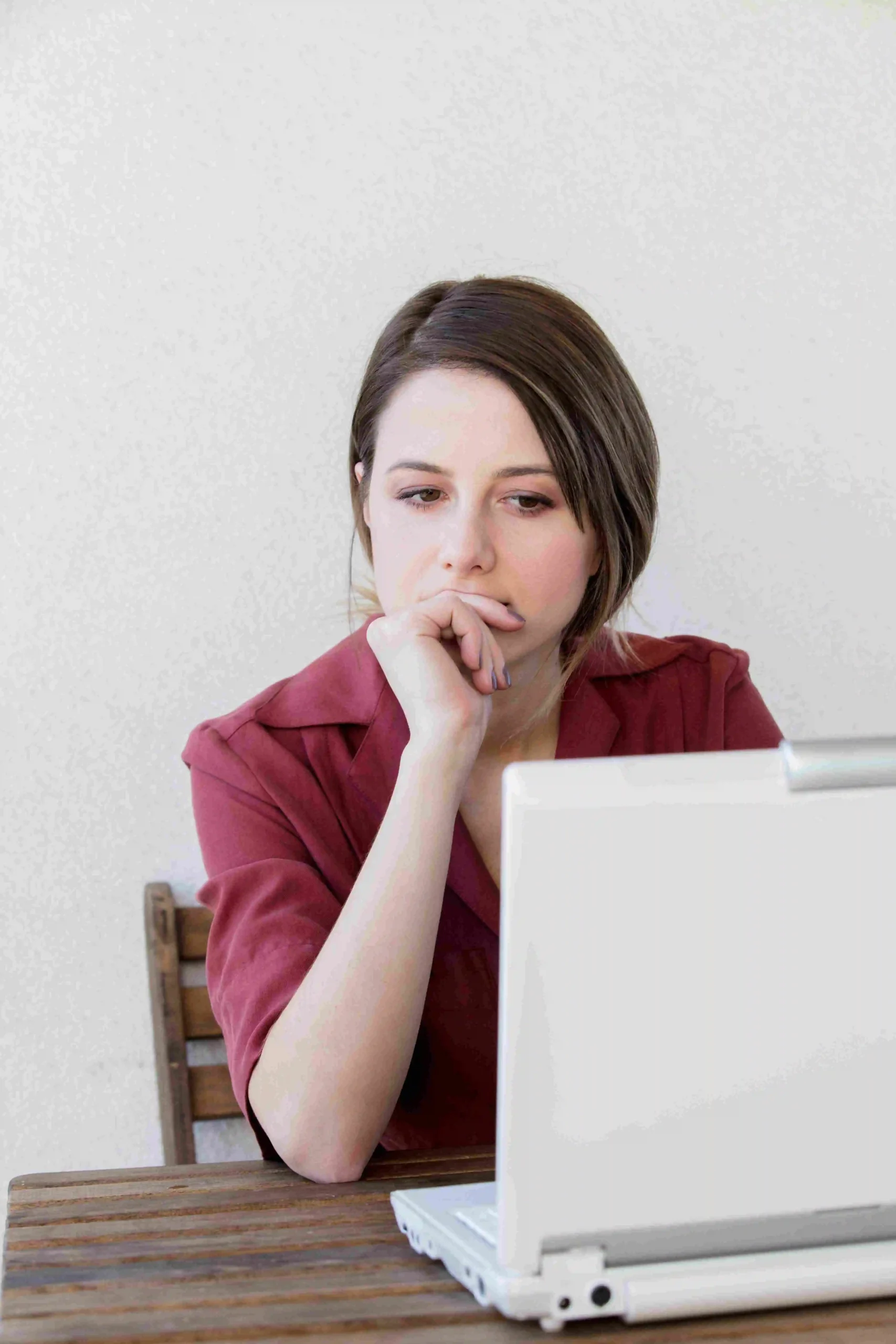 A woman using a laptop while seated at a table.