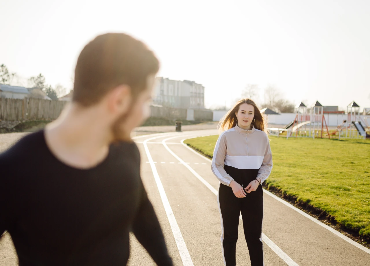 a man and woman standing on a track