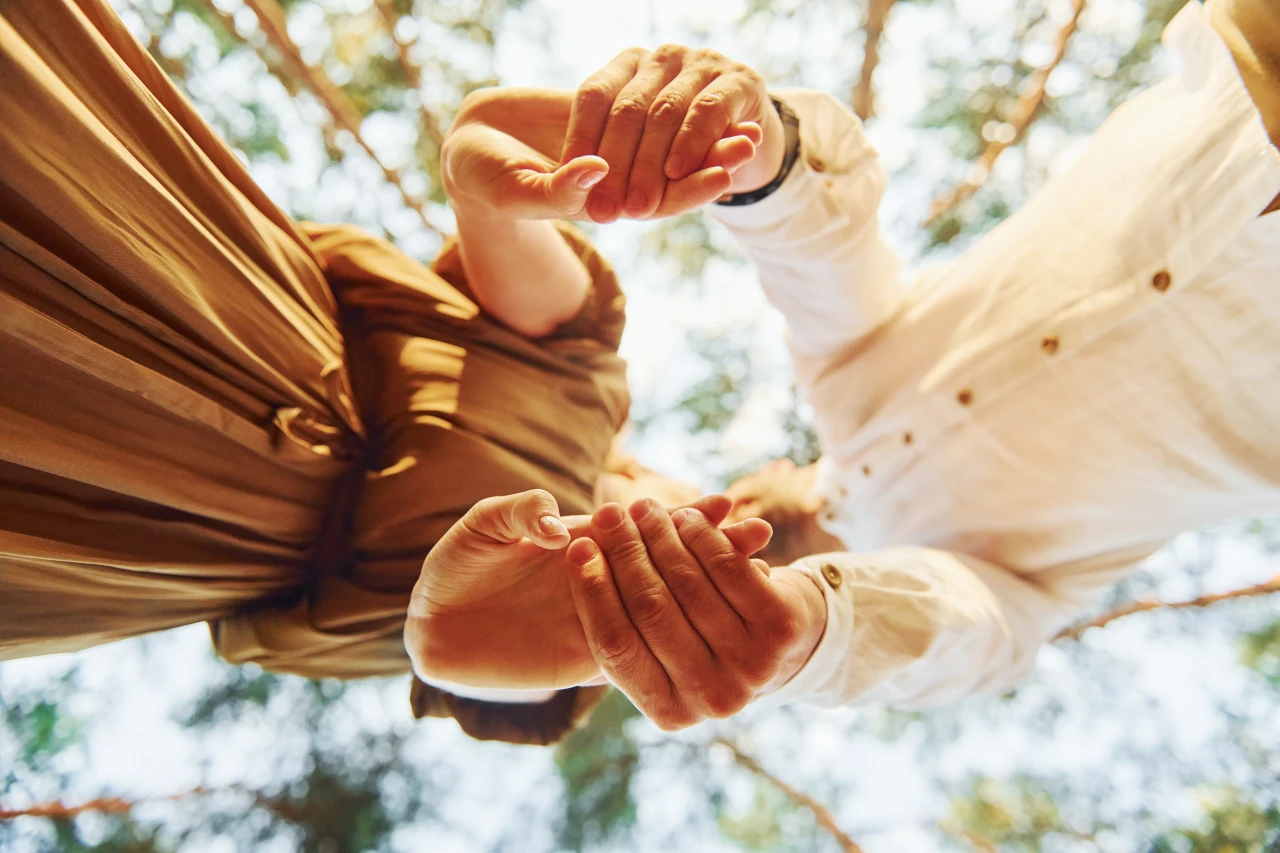 A man and woman joyfully hold hands symbolizing unity and connection in a vibrant setting.