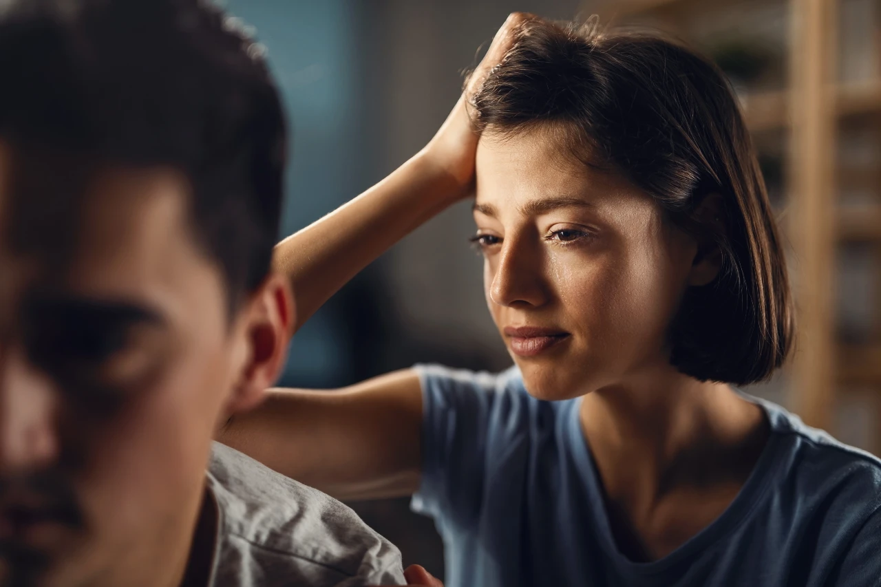 a sad woman touching her head with her hand