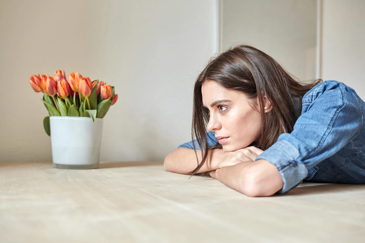 a woman leaning on a table with her head on her hands