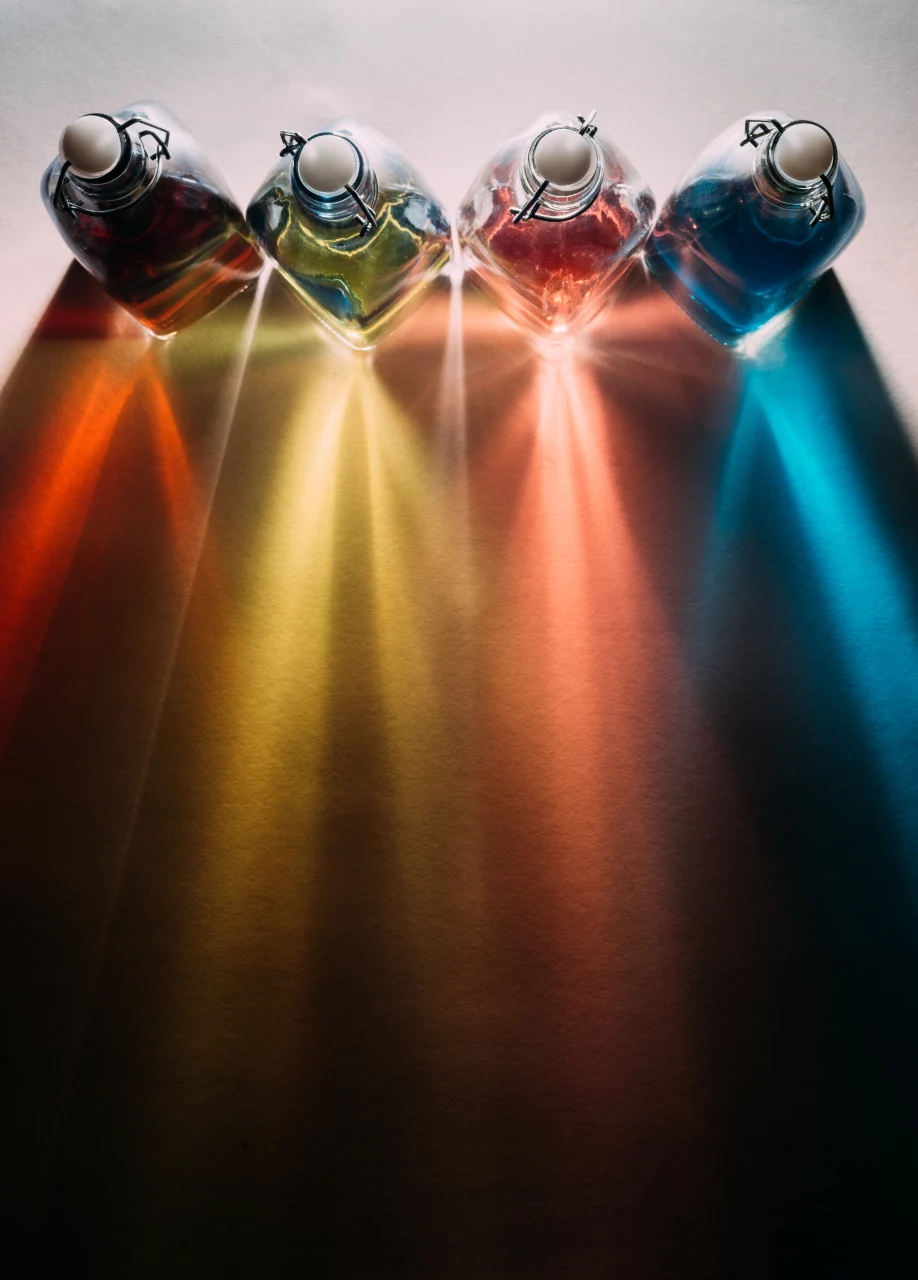 A lineup of bright bottles, each reflecting light, creating a visually striking display of colors.